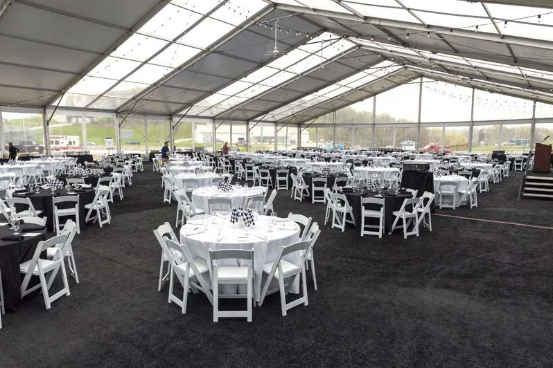 Several black and white tables and chairs in an indoor enclosure